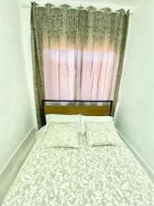 a bed in a room with a window with a bedspread at Piramides 1 Apartment in Madrid