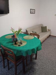 a green table in a living room with a couch at Mieszkanie Apartament Lord , Parking Bezpłatny in Toruń