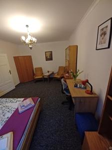 a hotel room with a bed and a desk and a table at Mieszkanie Apartament Lord in Toruń