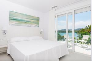 ein weißes Schlafzimmer mit Bett und Meerblick in der Unterkunft NEW! Villa del Lago 2, Alcudia Beach, Mallorca in Port d'Alcúdia + 19 Fotos