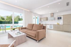 ein Wohnzimmer mit Sofa und Tisch in der Unterkunft NEW! Villa del Lago 2, Alcudia Beach, Mallorca in Port d'Alcúdia
