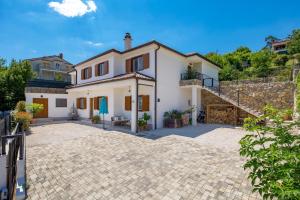 a large white house with a brick driveway at Apartment Niki in Opatija