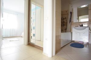 uma casa de banho com um chuveiro, um lavatório e um espelho. em Brates Apartment em Iaşi