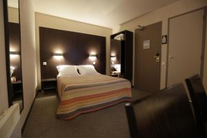 Postel nebo postele na pokoji v ubytování Hôtel Au Petit Caporal