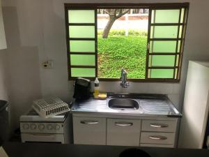 uma cozinha com um lavatório e uma janela em Pesqueiro Rancho Feliz em Fama