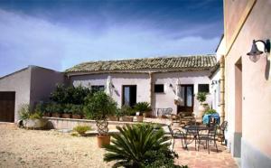 a house with a patio with a table and chairs at Agriturismo Baglio Donna Santa in Dattilo