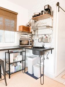 cocina con encimera negra y mesa en Spotless Modern studio, en Inglewood