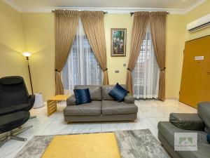 a living room with a couch and two large windows at Palisades Peaks Luxury Apartments in Lekki