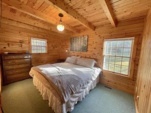 1 dormitorio con 1 cama en una cabaña de madera en Log Home w Mountain Views Near Windham & Hunter Ski Resorts, en Maplecrest