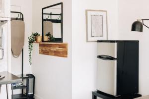 a kitchen with a refrigerator and a mirror on the wall at Spotless Modern studio in Inglewood