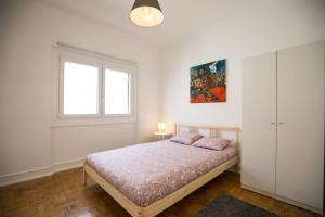 a bedroom with a bed and a window at Hoso Beach House in Costa da Caparica