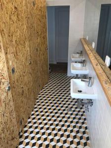 a bathroom with two sinks and a checkered floor at Hoso Beach House in Costa da Caparica