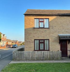 a brick house with a fence in front of it at Cosy 2 bed, home from home in Haddenham