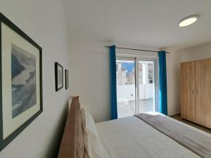 科托尔Paun apartment的一间卧室，里面有一张床和一扇推拉玻璃门