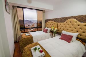 a hotel room with two beds and a window at Hotel & Apartments Davesa House in Cusco