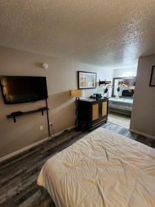 a bedroom with a bed and a flat screen tv at Branson Ozarks Inn in Branson