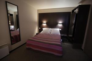 Postel nebo postele na pokoji v ubytování Hôtel Au Petit Caporal
