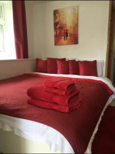 uma cama com toalhas vermelhas em cima em Cannock Chase Guest House Self Catering incl all home amenities & private entrance em Cannock
