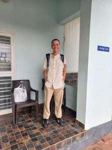 a man standing in a room with a chair at Sun n Tan Beach Home stay in Kannur