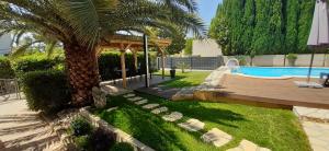un patio trasero con una palmera y una piscina en Terra Mare, en Medulin