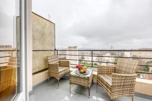 a balcony with chairs and a table with flowers on it at Les Bleus de Paris studio flat in Gentilly