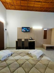 1 dormitorio con 1 cama grande, mesa y TV en La Corte Felice, en San Donato Milanese