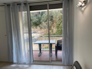 szklanymi drzwiami ze stołem na balkonie w obiekcie Moderne T2 cassis plein centre Climatisé - 200 m du port w Cassis