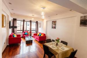 sala de estar con sillas rojas y mesa en Hotel & Apartments Davesa House, en Cusco