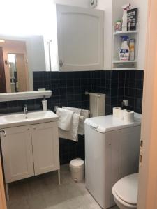 a bathroom with a white sink and a toilet at Le ROS ÉDEN in Saint-Hilaire-de-Riez +6 photos