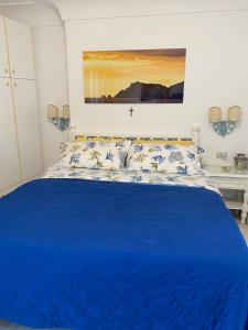 a bedroom with a blue bed with a cross on the wall at Longano 35 in Capri