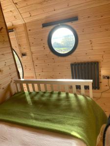 1 dormitorio con ventana en una cabaña de madera en Powder Mill en Ponsanooth