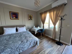 a bedroom with a bed and a table and a window at Elegant and cozy room ARAKS in Kostinbrod