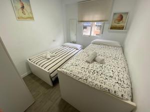 duas camas num pequeno quarto em Apartamento Vistafranca em Málaga