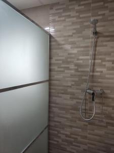 eine Dusche im Bad mit Ziegelwand in der Unterkunft Apartament Cristina in Deltebre