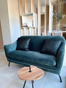 a green couch in a living room with a wooden table at Appartement centre de Roanne 38m2 in Roanne