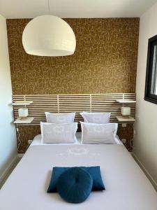 - un grand lit blanc avec un oreiller bleu dans l'établissement Appartement centre de Roanne 38m2, à Roanne