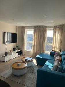 a living room with a blue couch and a tv at 2 Bedroom Chelsea Apartment in London