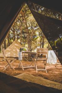 a tent with two chairs and a table and a bench at TAIGA Conil in Conil de la Frontera