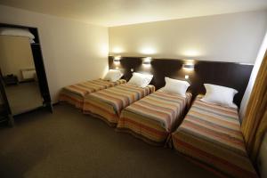 Postel nebo postele na pokoji v ubytování Hôtel Au Petit Caporal