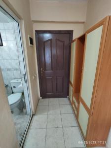 a bathroom with a brown door and a toilet at Caner Mountain Hotel in Antalya