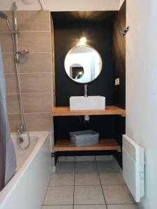 une salle de bains avec lavabo, miroir et baignoire dans l'établissement Studio Grand Balcon Montagne Ski et Randos, à Luz-Saint-Sauveur