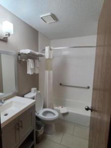 a bathroom with a shower and a toilet and a sink at Super 8 by Wyndham Bedford in Bedford