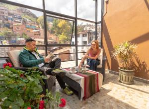 un hombre y una mujer sentados en sillas en un balcón en Hotel & Apartments Davesa House, en Cusco