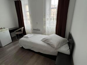 a small bed in a small room with a window at Pension NV in Lutherstadt Eisleben