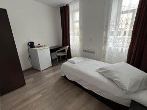 a bedroom with a bed and a desk and a window at Pension NV in Lutherstadt Eisleben