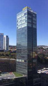 a tall glass building with a sign on top of it at Distrito in Mexico City