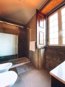 a bathroom with a shower and a toilet and a sink at Casa da Tanquinha in Beiral do Lima +97 photos