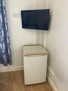 un pequeño armario blanco con TV en la pared en Lovely Studio Flat @ 10C Nearby Sea Front, en Ryde