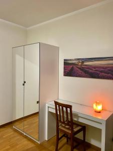 Habitación con escritorio, silla y pintura en civico 38, en Bassano del Grappa