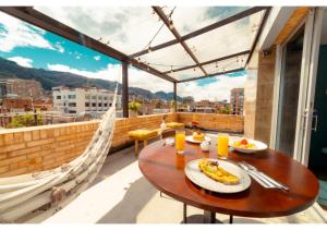 a table on a balcony with a view of a city at Selina Parque 93 Bogota in Bogotá